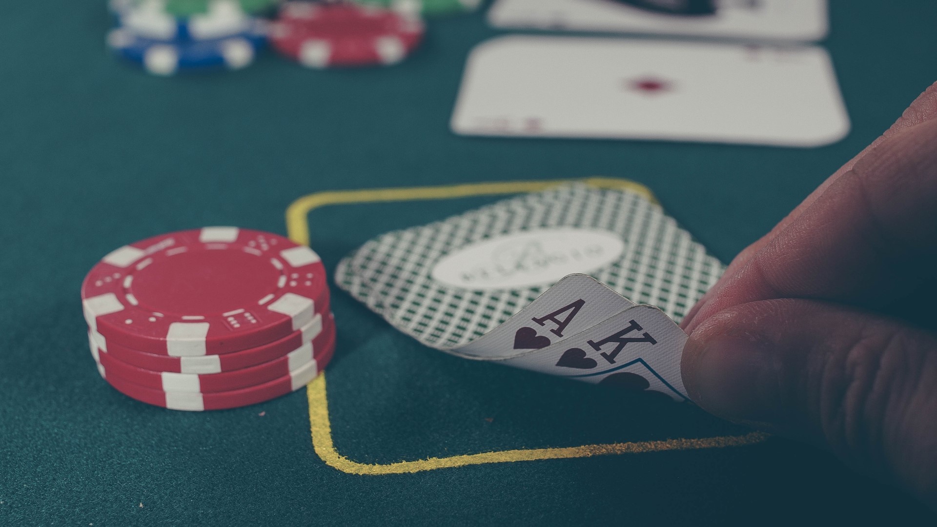 Poker rules how to play poker a pair of cards and chips, credit to Unsplash Michał Parzuchowski